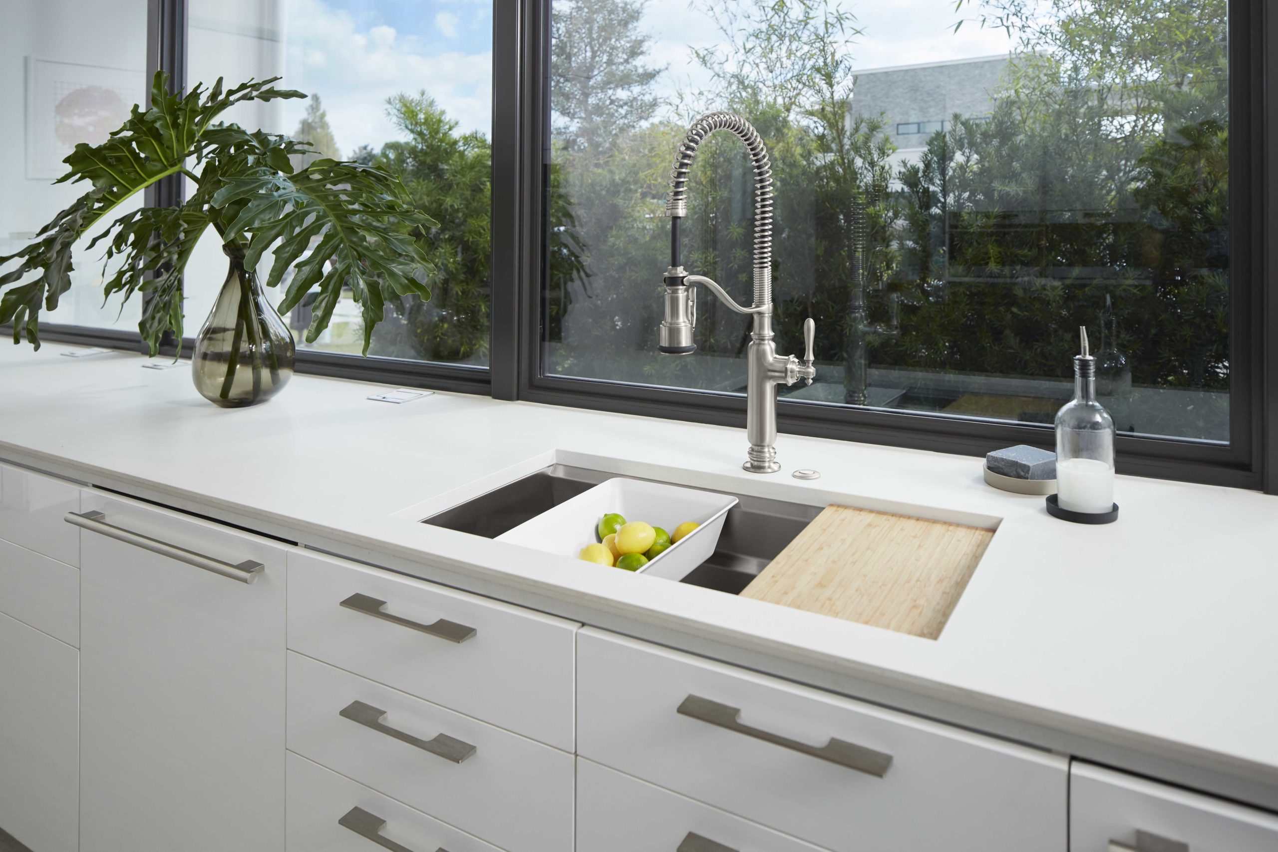 silver faucet with white kitchen countertop and cabinets