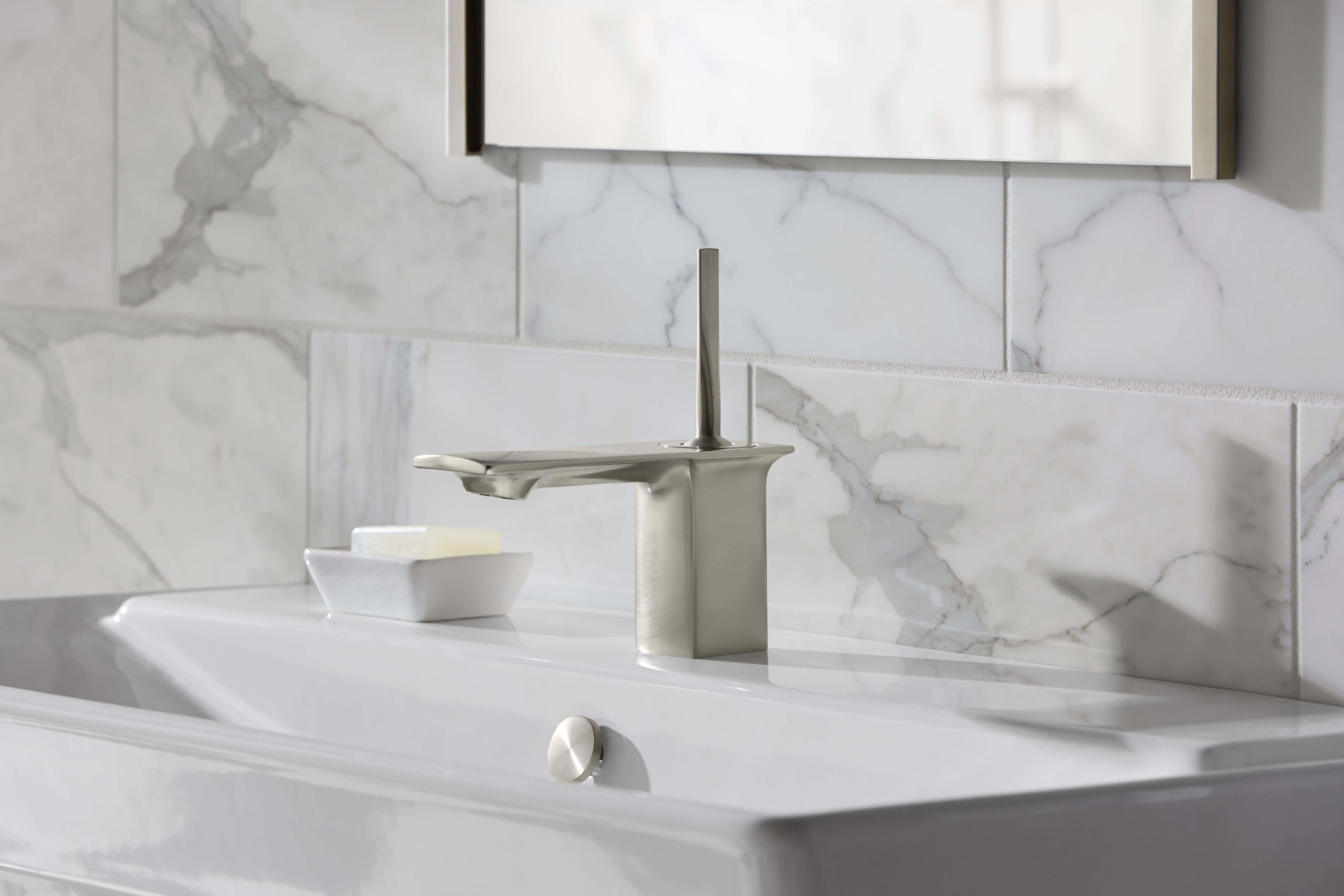 silver faucet with white and gray marble backsplash and walls